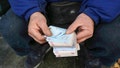 A street money exchanger poses for a photo without showing his face as he counts Iranian banknotes at a commercial district in downtown Tehran, Iran, Dec. 23, 2022. - Fox News