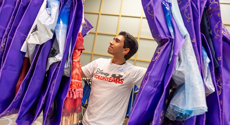 Disney cast member looks over Wish outfits