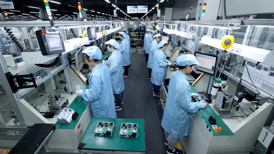 Workers work on a production line manufacturing smart automotive central control navigation products at a factory of Beidou Intelligent Connected Vehicle Technology Co. (BICV) in the High Tech Industrial Development Zone in Suqian, Jiangsu Province, China April 9, 2025. 