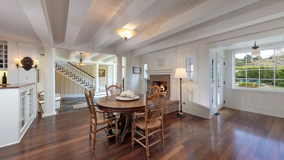 The breakfast room features a wood-burning fireplace and a round table for four.