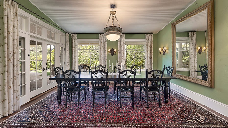 The dining room features green walls, floor-to-ceiling windows and many windows.