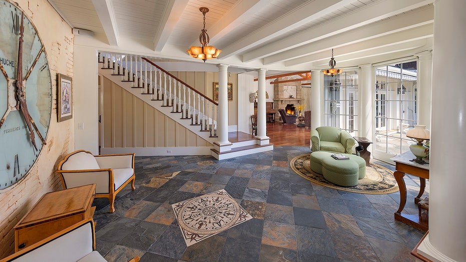 The east wing foyer features black tiled flooring and floor-to-ceiling windows.