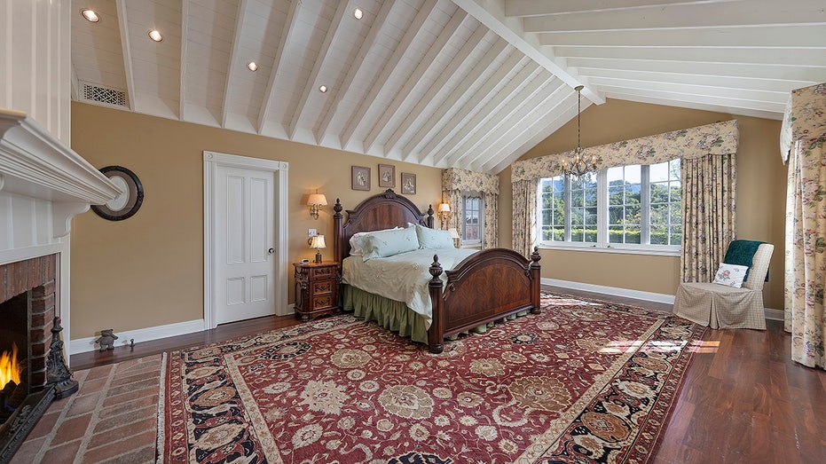The primary bathroom features a wood-burning fireplace and a vaulted ceiling.