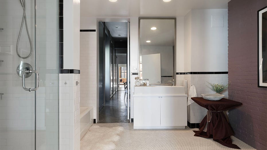The ensuite bathroom features a standing shower and a bathtub.