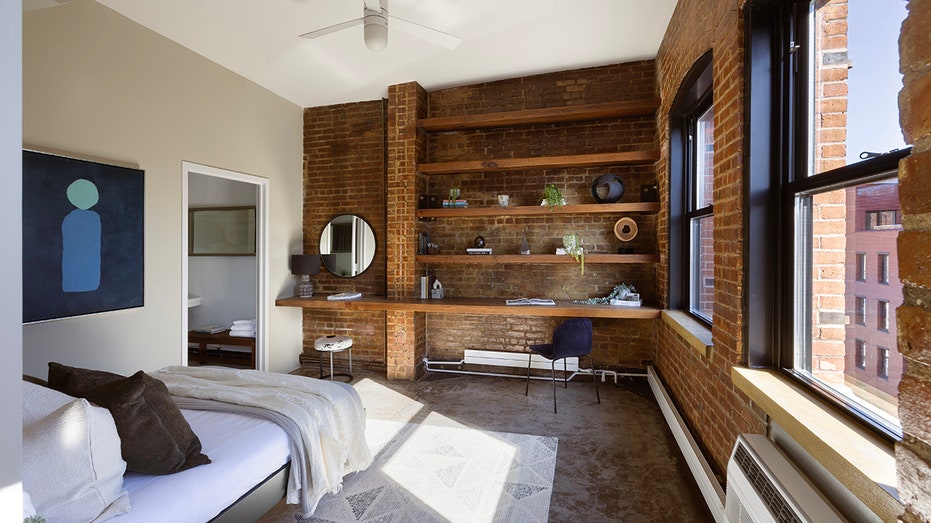 One bedroom features exposed brick walls and built-in shelves.