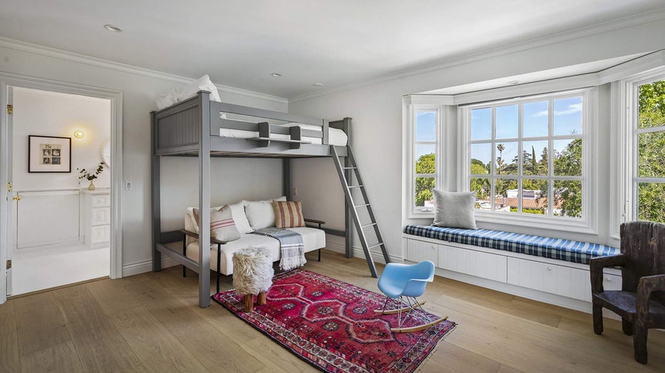 One of the bedrooms features a loft bed and a cushioned bench beneath the window.