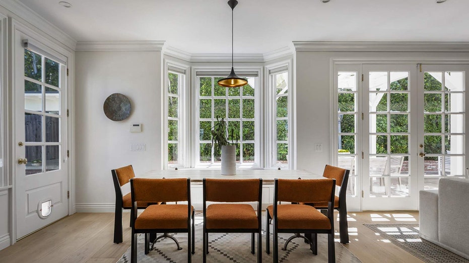 The secondary dining area features a table placed in front of a window with a cushioned bench.