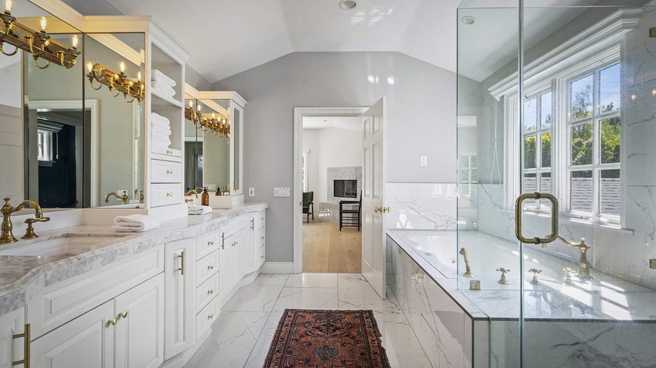 The ensuite bathroom features a standing shower and a tub.