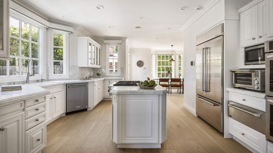 The kitchen features all stainless-steel appliances and a large center island.