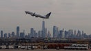A United Airlines airplane takes off at Newark Liberty International Airport in front of the skyline of lower Manhattan and One World Trade Center in New York City on February 20, 2025, in Newark, New Jersey.