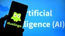 INDIA - 2025/03/05: In this photo illustration, a Duolingo logo is seen displayed on a smartphone with an Artificial Intelligence writing in the background.