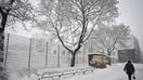 A pedestrian walks across a street during a snowy spring day in Vantaa, Finland, on April 23, 2024. Finland experienced exceptionally snowy weather for late April that caused chaos in commuter traffic, halted tramlines and delayed airport departures. - Fox Business News