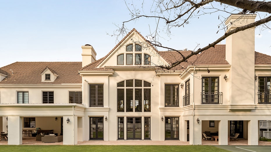 The home's backyard features a covered porch with multiple seating areas.