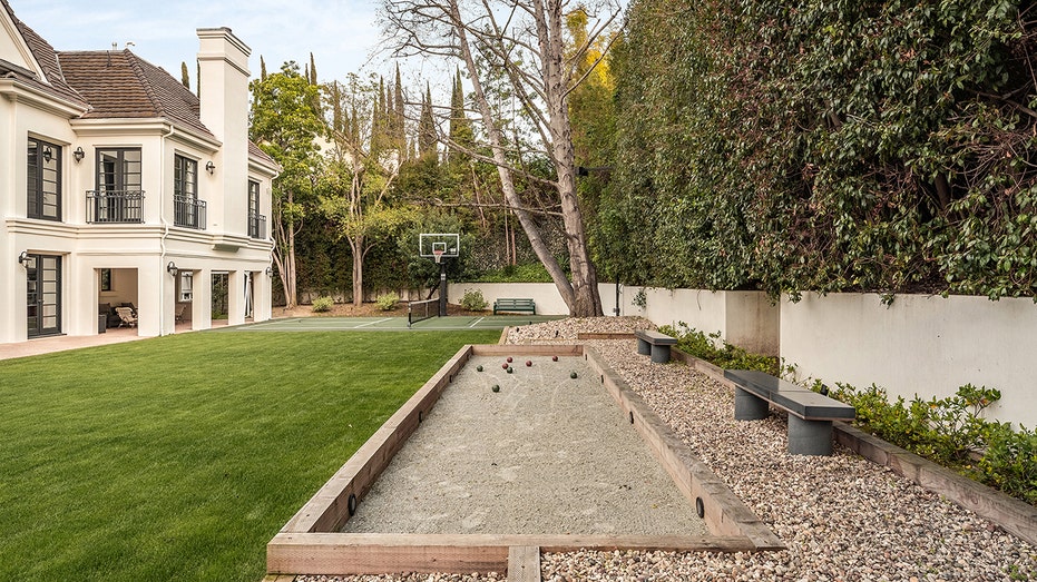 The backyard also features a combined basketball and pickleball court, as well as a bocceball court.