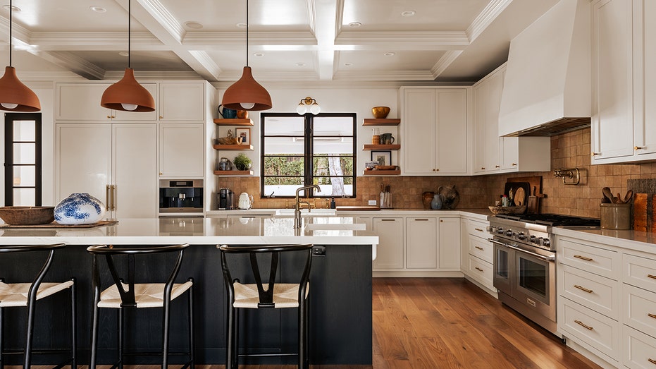 The kitchen features a large eat-in center island as well as a double oven and white counters.