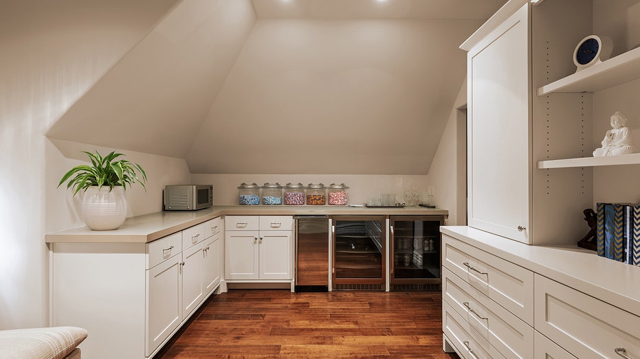 The butler's pantry includes two mini fridges and white shelves.