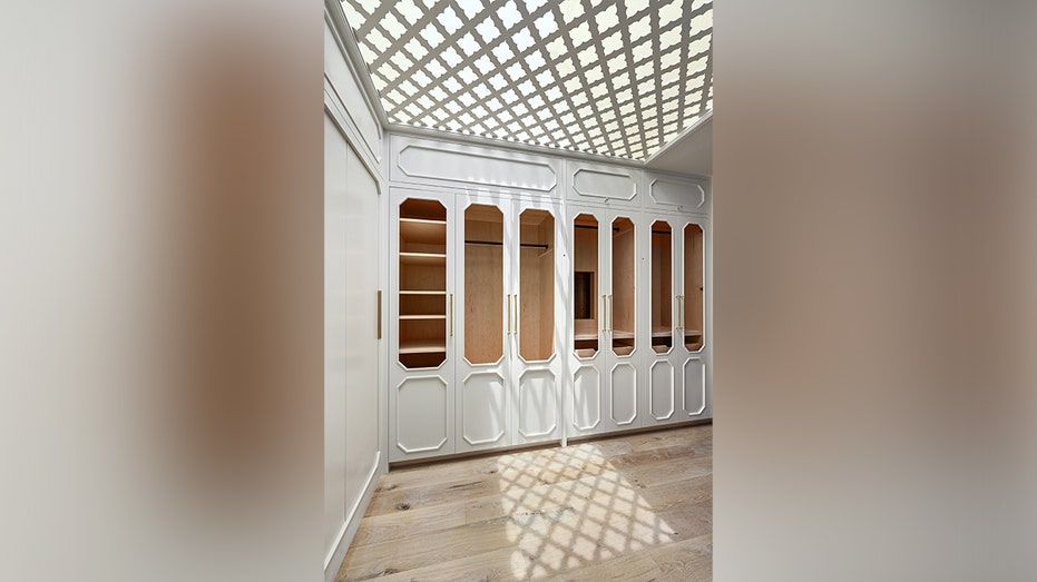 The walk-in closet features a unique ceiling.
