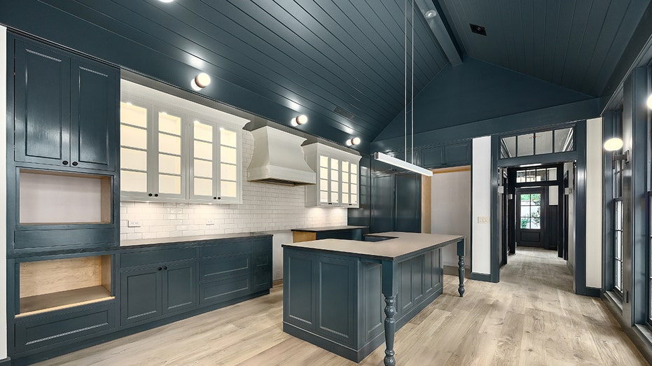 The kitchen in the guesthouse is lined with blue cabinets.