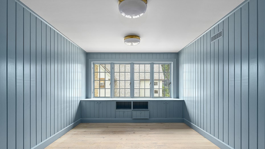 The home also includes a blue wood-paneled room.