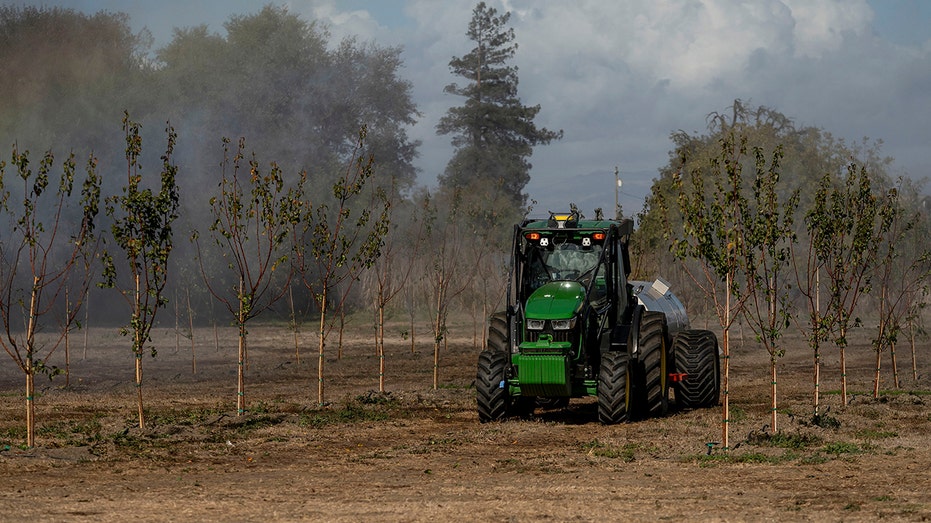 John Deere autonomous orchard tractor in field 
