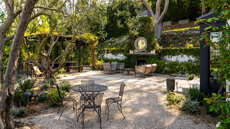 The garden has a burning fireplace in front of a fire area.