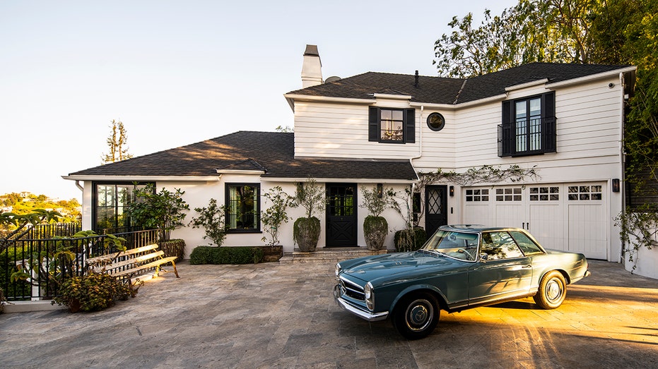 A long driveway leads to the home's motorway and garage, which boasts a bench looking out on the picturesque view.