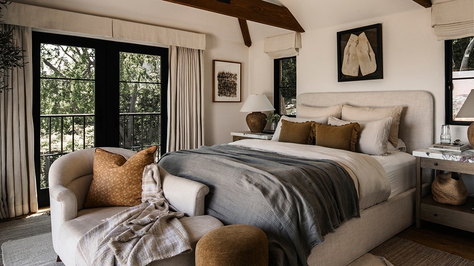 The main bedroom has wooden beam ceilings, hard wooden floors and many windows.