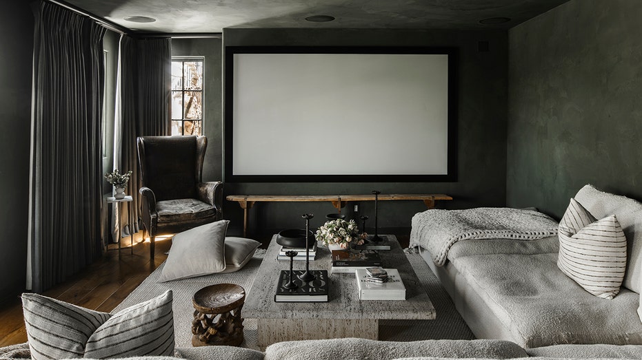 The media room features dark gray walls and a large projection screen.