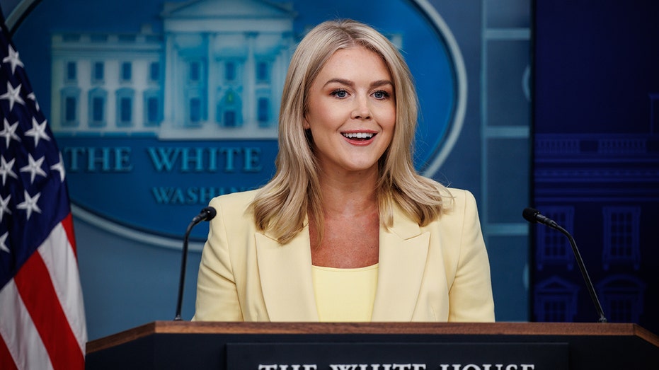 Leavitt in a yellow blazer in WH briefing room