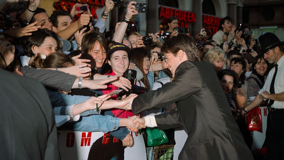 American actor Tom Cruise greets fans outside the UK film premiere of Brian De Palma's 'Mission Impossible' at the Empire cinema, Leicester Square, London, July 1996. (Photo by Dave Benett/Getty Images)