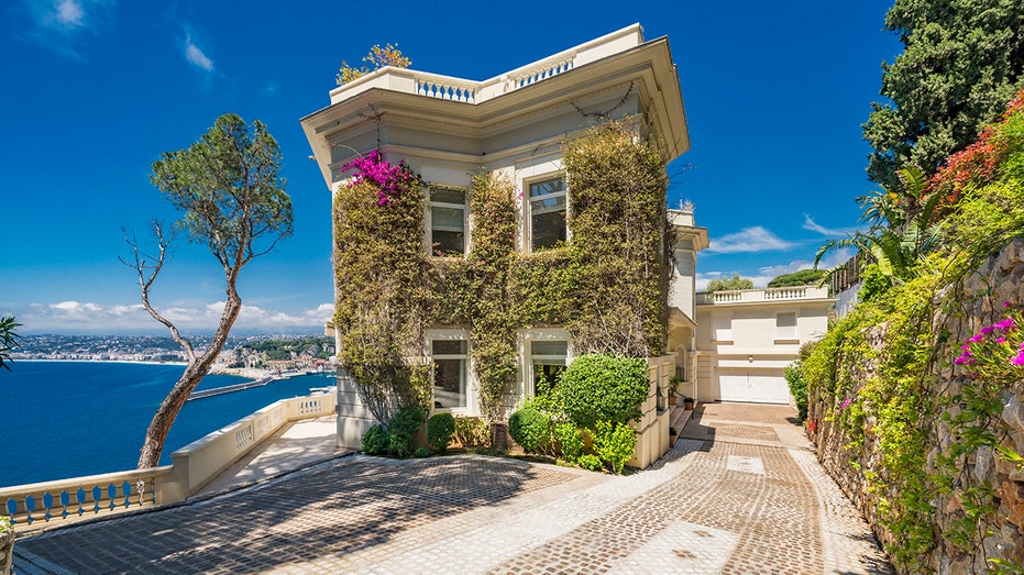 The villa on the French Riviera is covered in vines and has walkways with views of the Mediterranean.