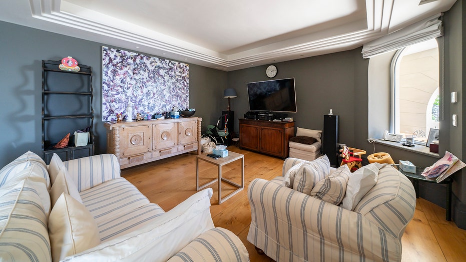 The living room features coffered ceilings, hardwood floors and a flat-screen TV.