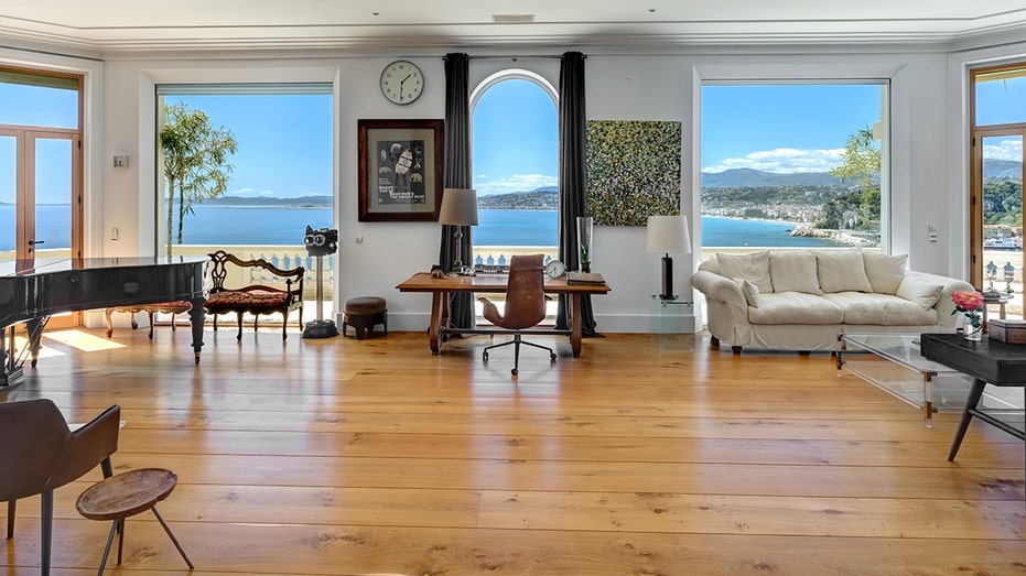The reception room features floor-to-ceiling windows.