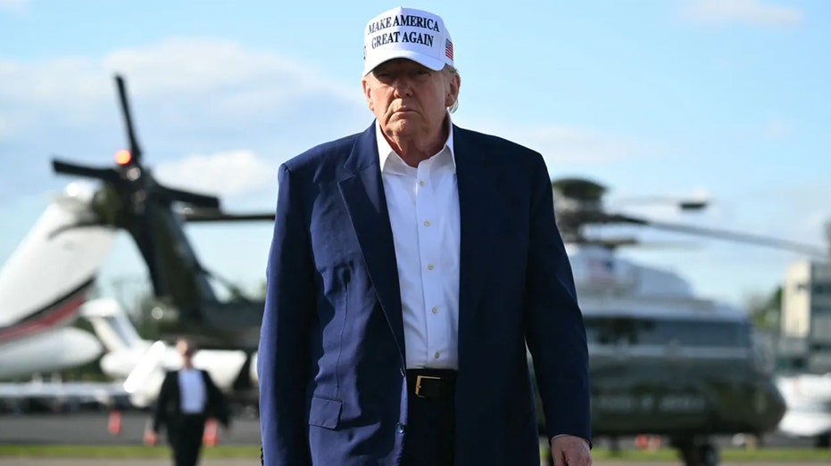 US President Donald Trump walks to speak to journalists