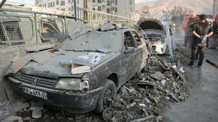 People gather near damaged vehicles in the aftermath of Israeli strikes, in Tehran, Iran, on June 13, 2025. - Fox Business News