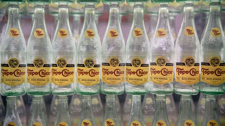 Bottles of Topo Chico mineral water⁤ on ⁣display.
