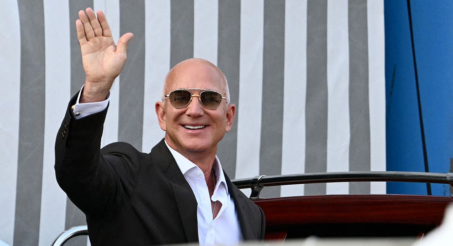 Amazon's founder Jeff Bezos waves as he gets on a taxi boat at the Aman Hotel in Venice on June 26, 2026. Celebrities in superyachts sail into Venice this week for the three-day wedding party of Amazon tycoon Jeff Bezos and Lauren Sanchez, despite irate locals who say the UNESCO city is no billionaire's playground. The tech magnate and journalist have reportedly invited about 200 guests to their multi-million dollar nuptials in the Italian city, which are expected to kick off on June 26 and end Saturday with a ceremony at a secret location. (Photo by Stefano Rellandini / AFP) (Photo by STEFANO RELLANDINI/AFP via Getty Images)