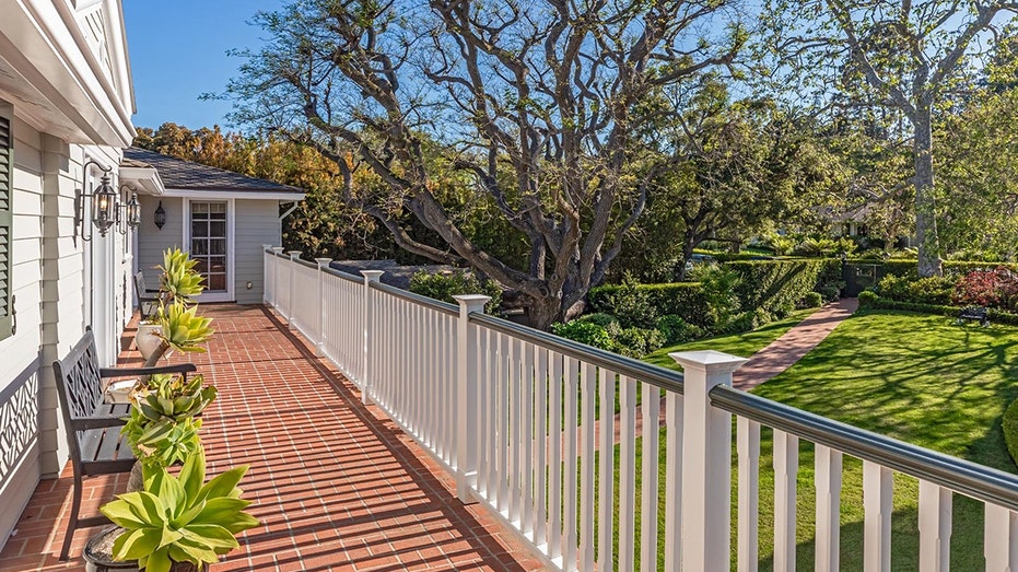 The upper level features a balcony lining almost the entire front exterior of the house.