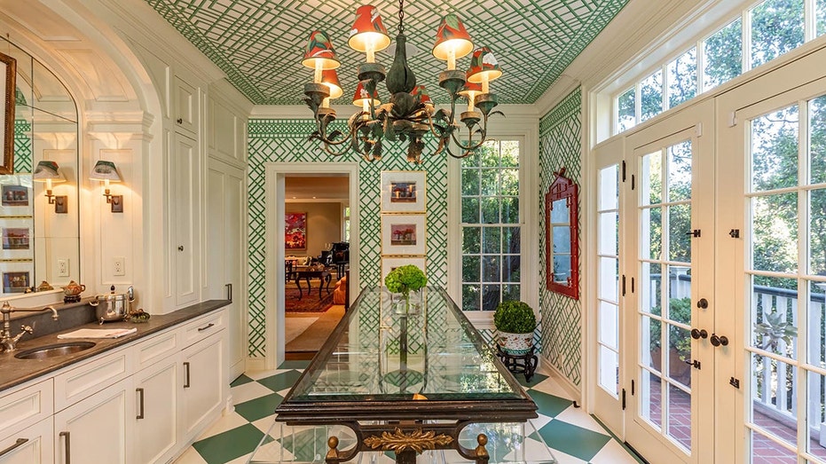 The conservatory features green and white tiles as well as green lattice design wallpaper.