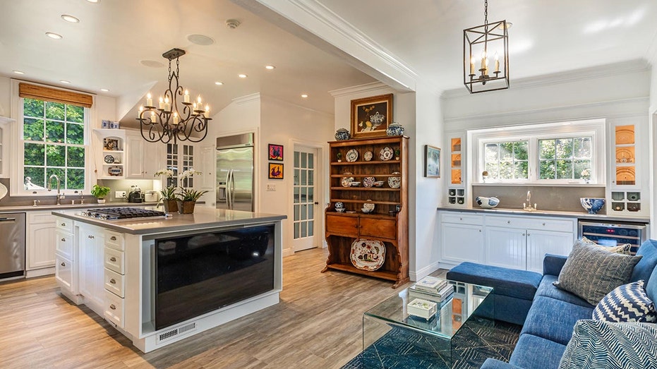 The kitchen includes a large center island with white cabinets and gray countertops.
