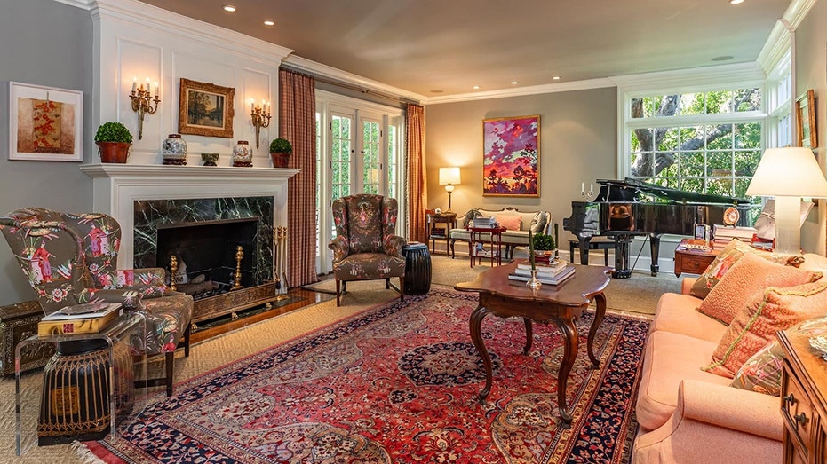The living room includes a wood-burning fireplace as well as multiple windows bringing in natural light.