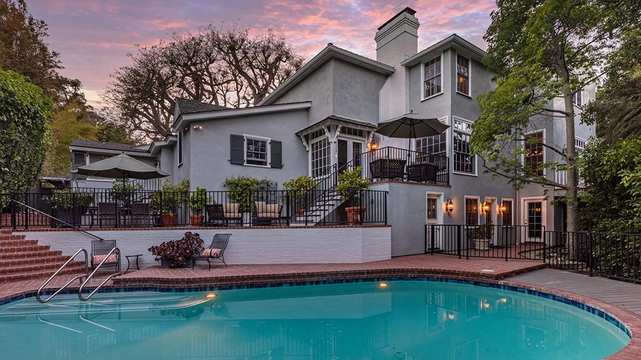The backyard features a large swimming pool and multiple outdoor seating areas.