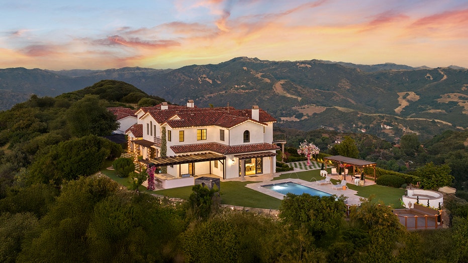 A house on a hill with views of the mountains.