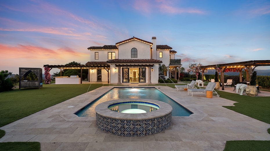 The backyard features a swimming pool and an outdoor kitchen.