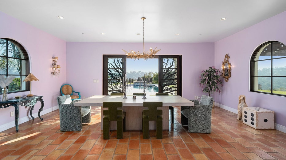 The dining room features purple walls and ornately decorated double doors leading to the backyard.