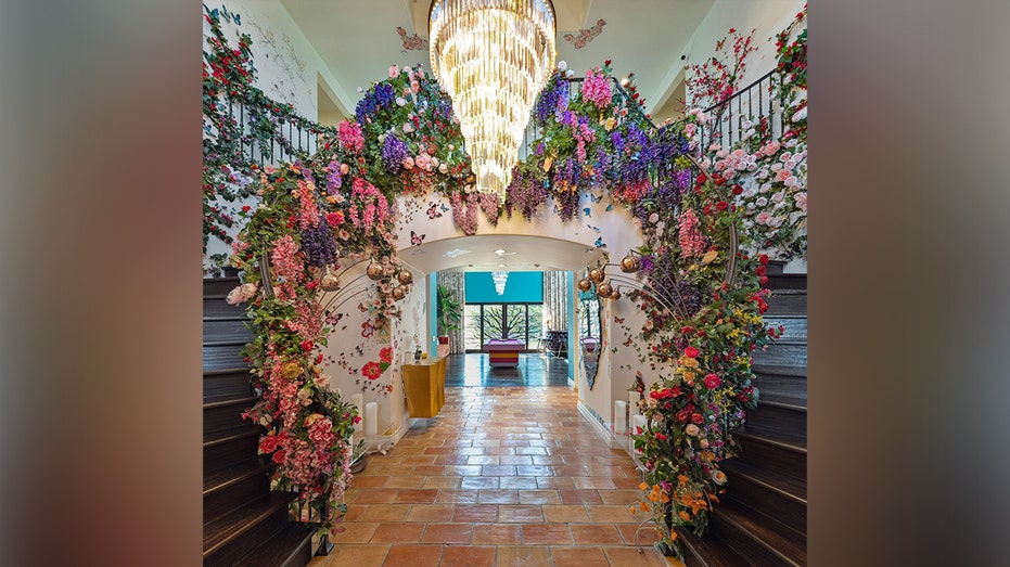 The entryway currently features flowers covering the railings of the staircases.