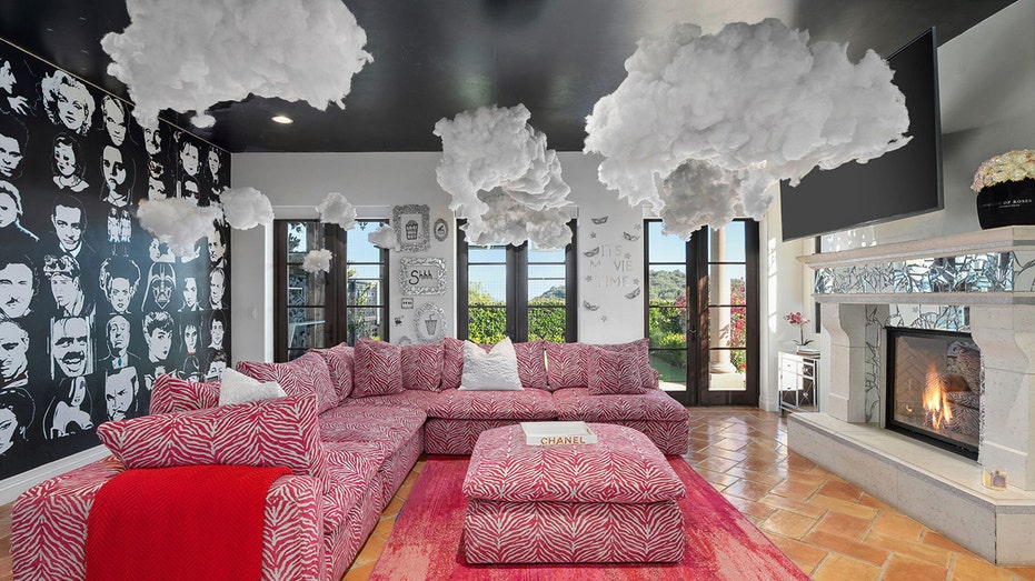 The media room features an accent wall as well as a wood-burning fireplace.
