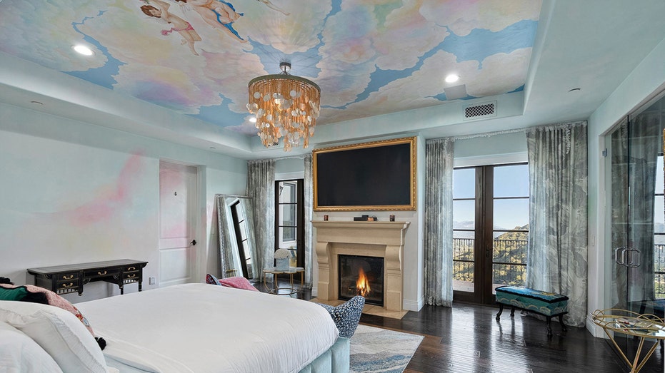 The primary bedroom features a wood-burning fireplace and a ceiling painted to look like the sky.
