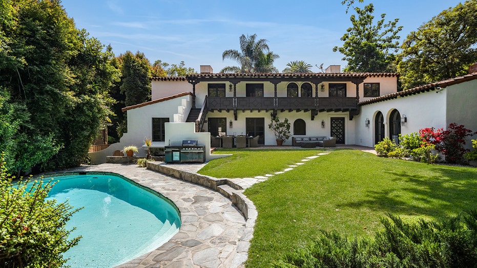 The backyard features a swimming pool and an outdoor kitchen.