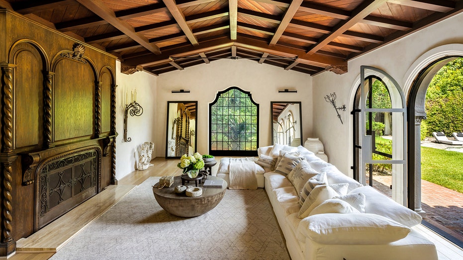 The living room features a wood-burning fireplace, coffered ceilings and big arched doors leading to the backyard.